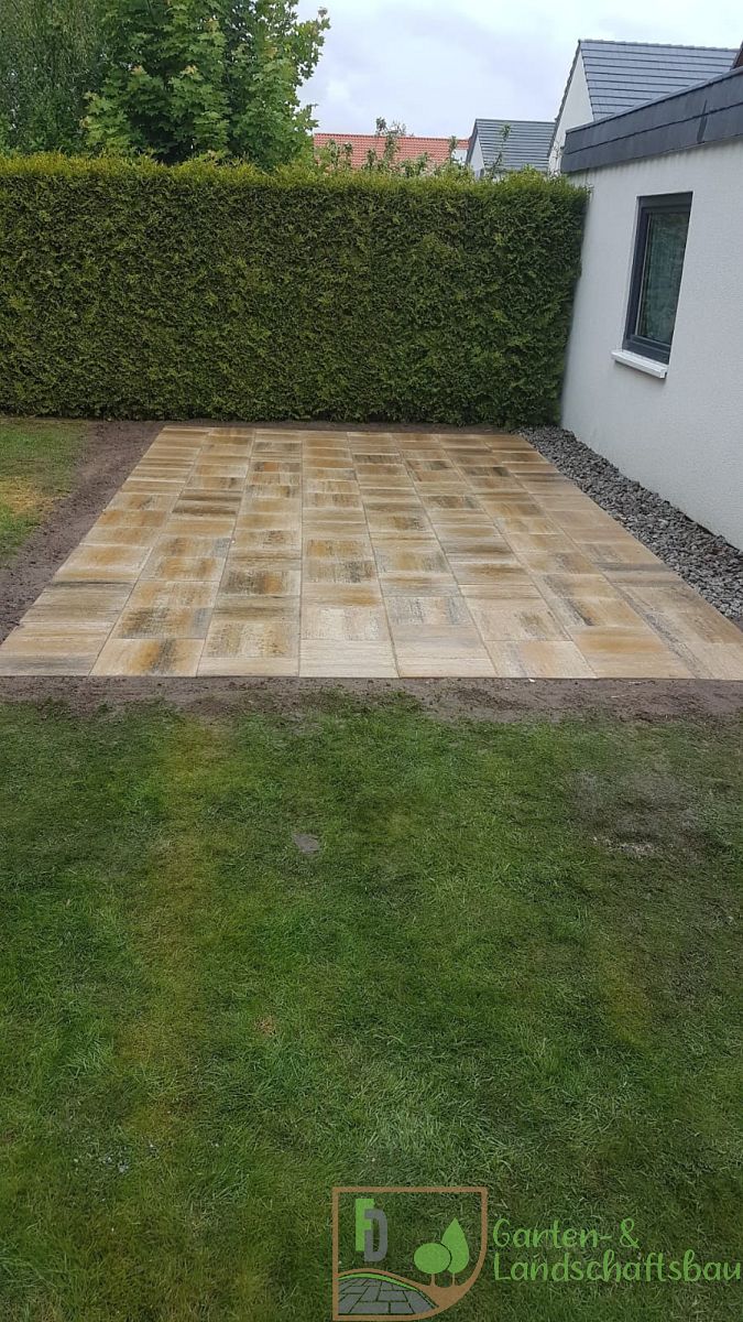 Terrasse aus Betonplatten mit Hecke