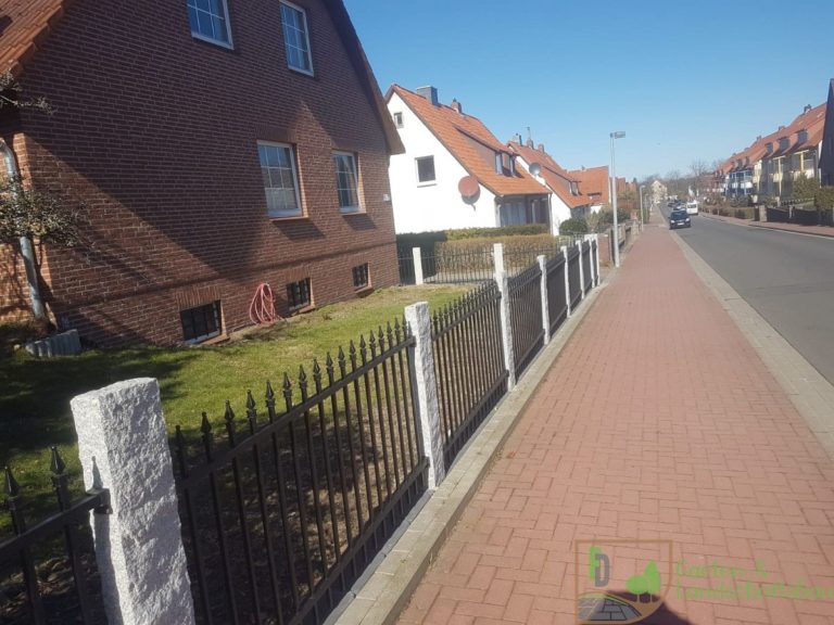 Vorgartenzaun aus Metall mit Granitpfosten an der Straße